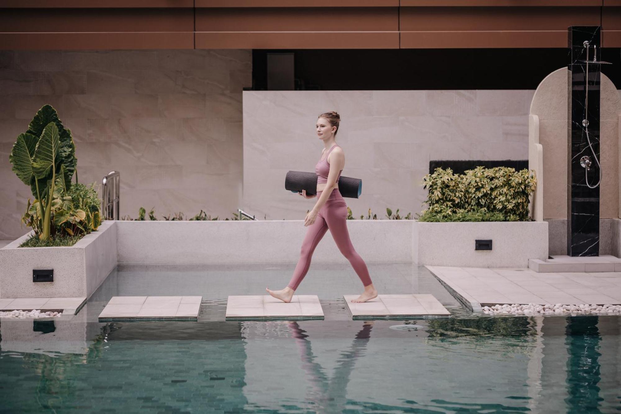 Nysa Hotel Bangkok Sukhumvit 11 ภายนอก รูปภาพ A woman walking on a stepping stone